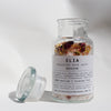 Revive Botanical Bath Salts 250gm in glass bottle, with lid off.